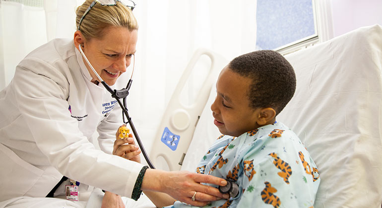 Doctor listening to the heart of a young boy