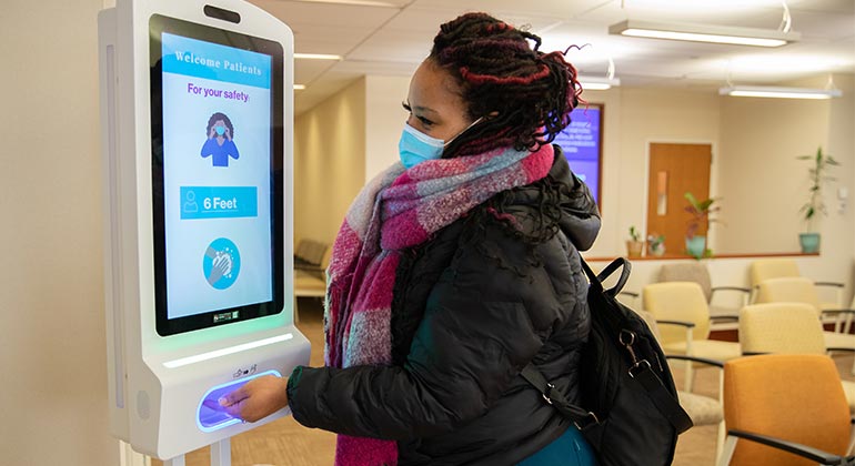 Masked patient using hand sanitizer