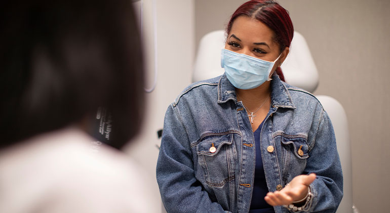 Masked patient talking to doctor