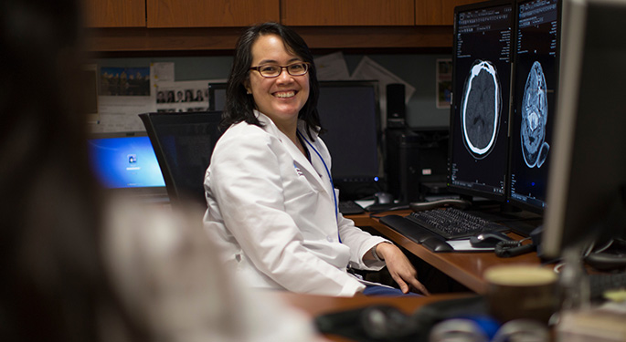 medical staff smiling and sitting behind a desk