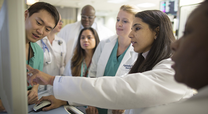 medical staff team over viewing information on a screen