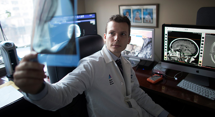 doctor sitting behind desk while looking behind him