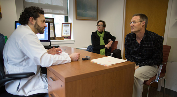 Doctor and patient family sitting around desk, talking