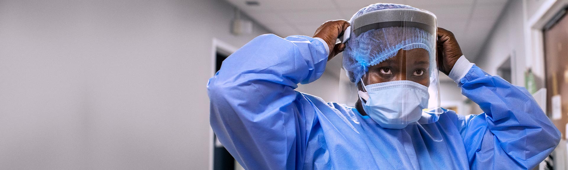 Nurse putting on PPE