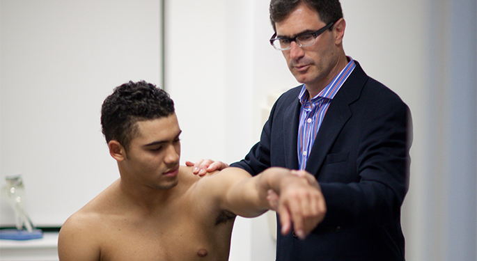 Image of Dr. James Gladstone examining male patient during office visit