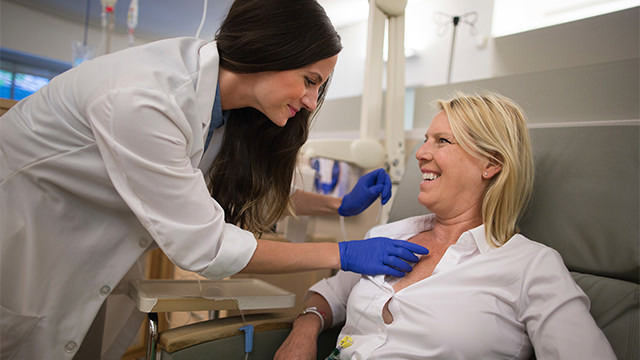 Woman in lounge chair as doctor talks to her