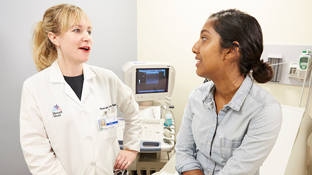 Doctor talking to woman in surgery room setting