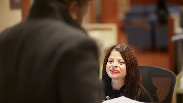 Woman at front desk speaking with patient