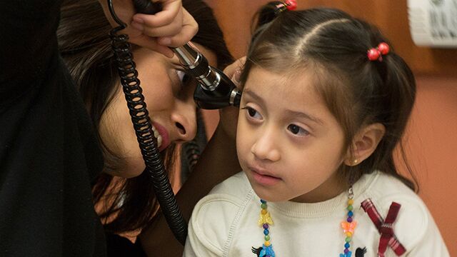 Doctor examining the inside of a little girl