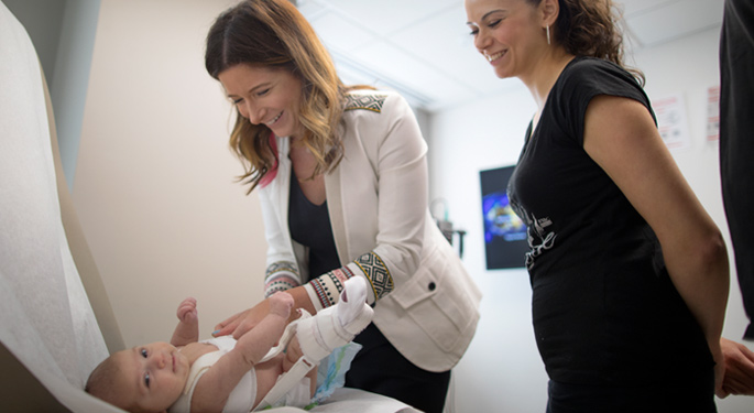 Orthopedic surgeon, Dr. Abigail Allen with infant patient and mother during office visit