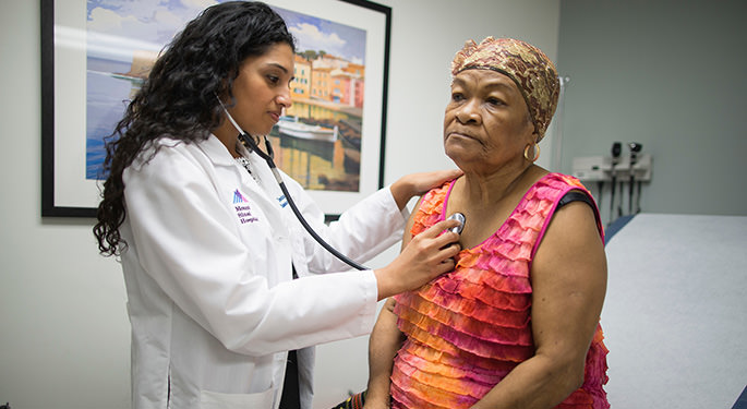 Dr. Deena Adimoolam taking the vital signs of a patient
