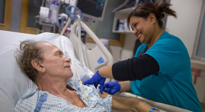 image of nurse checking a patient’s vitals in hospital room