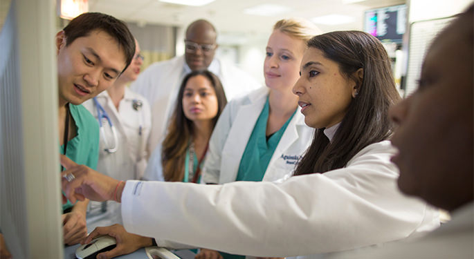 image of several doctors reviewing scans on a computer screen