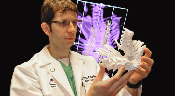 image of Dr. Caridi reviewing 3D printed model spine