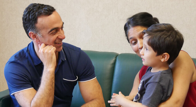 image of Dr. Saadi Ghatan with child patient and parent in consultation setting