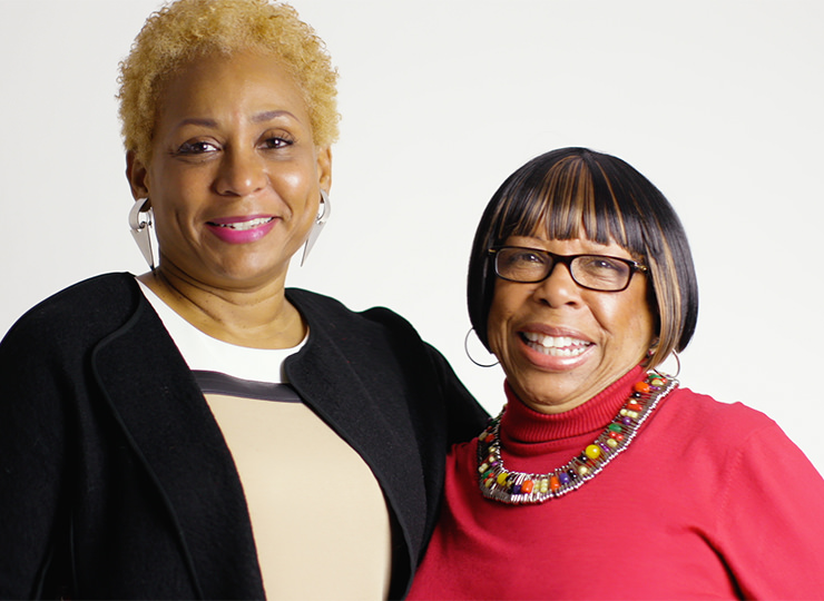 Photo of Two women standing side by side, smiling