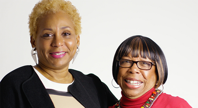 Two gynecological cancer survivors standing side by side, smiling