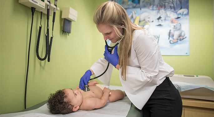 Female doctor examining baby