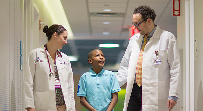 Boy standing between two doctors