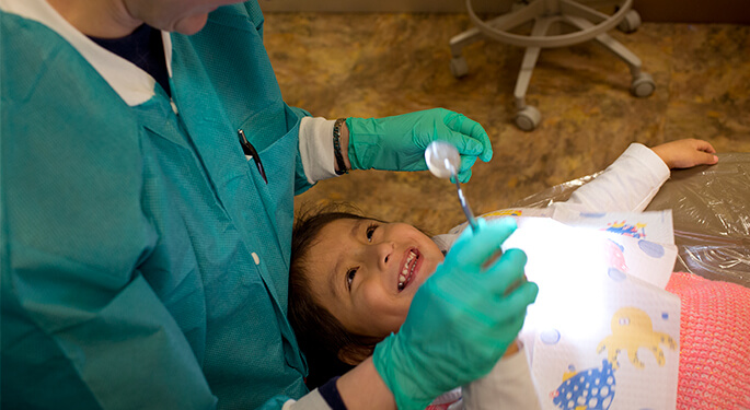 Dentist and young female patient in dental chair