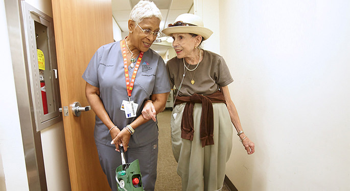 Two women walking down a hallway