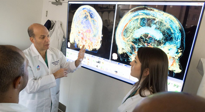 image of Dr. Bederson with various faculty, discussing brain scans on screen