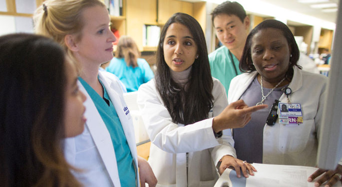 Image of several doctors in discussion by computer screen