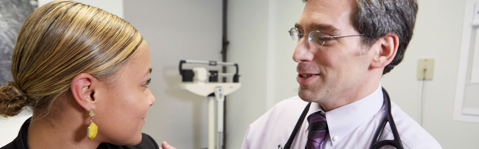 physician meeting with patient while she sits on chair