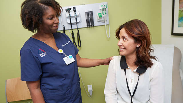 nurse and patient smiling at one another